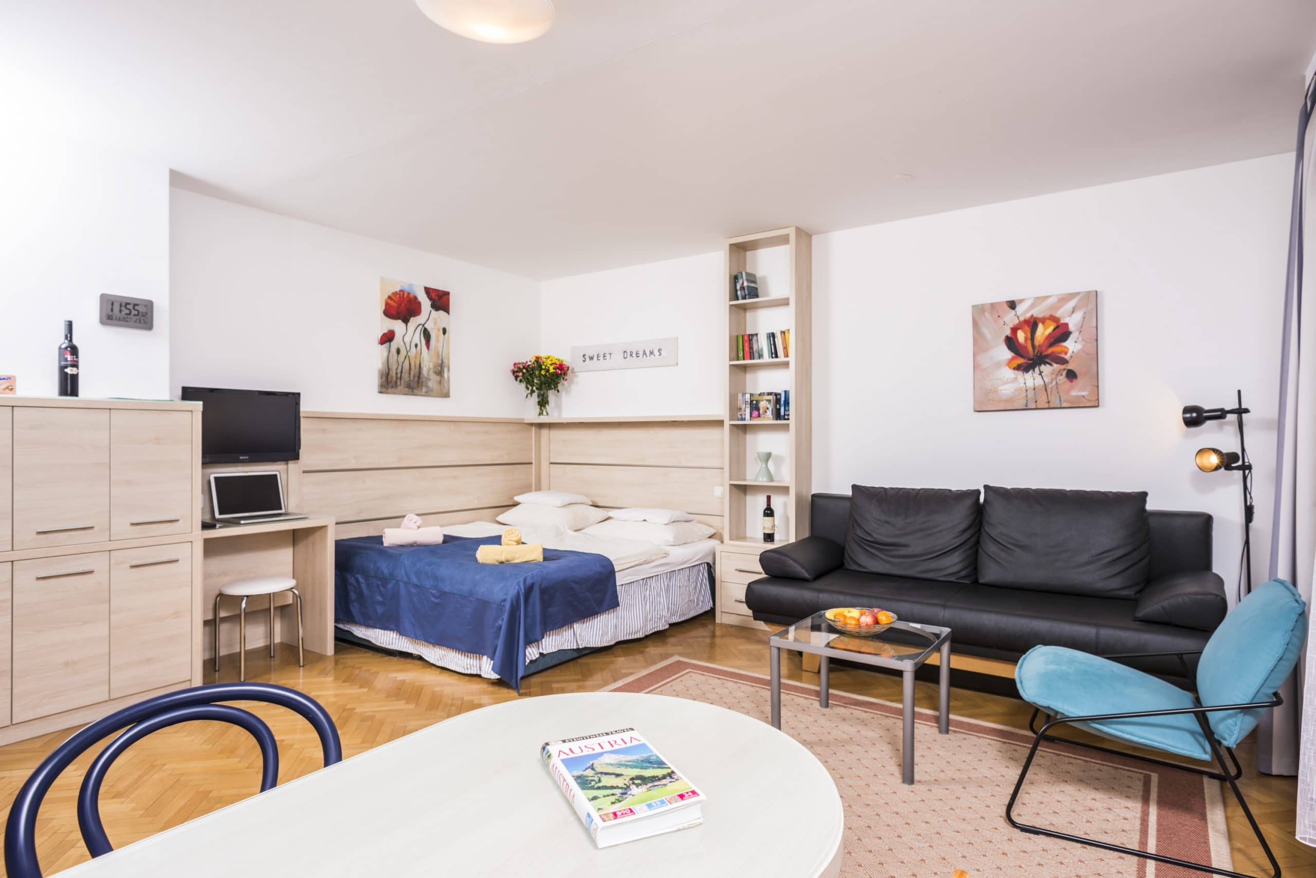Apartment R02 Wohnraum mit Sofa, Bett und Sessel