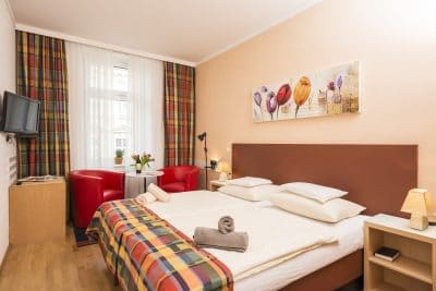 Apartment 5 Wohnraum mit Betten und gemütlicher Sitzgelegenheit