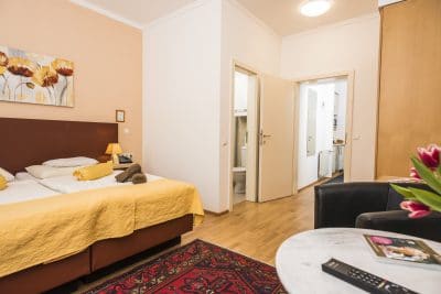 Apartment 6 Wohnraum mit Betten und kleinem Tisch