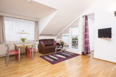 Apartment 2 Wohnzimmer mit Esstisch und Sofa